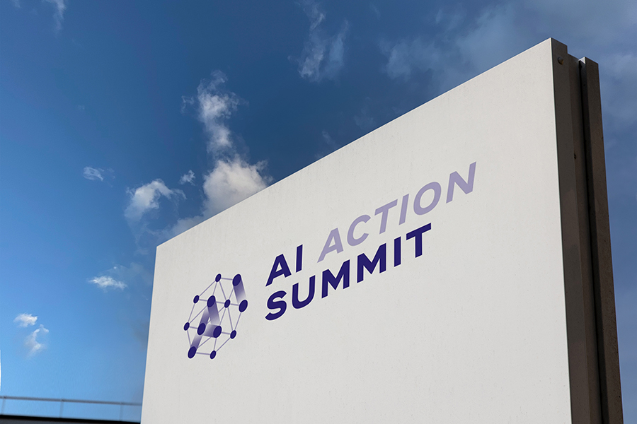 A large white sign for the AI Action Summit against a blue sky.